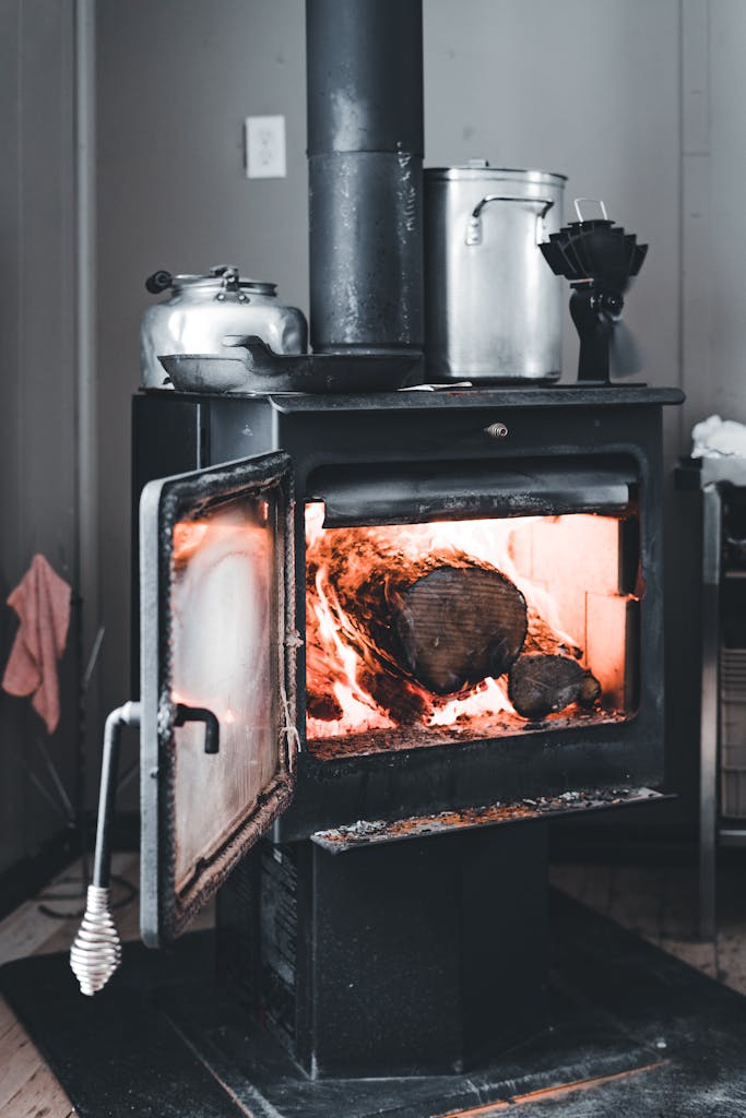 A warm wood-burning stove adds a cozy touch to an indoor space, perfect for cold seasons.